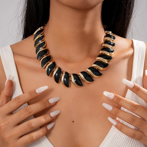 Collier vintage à feuilles en émail noir et couches dorées porté par un mannequin femme