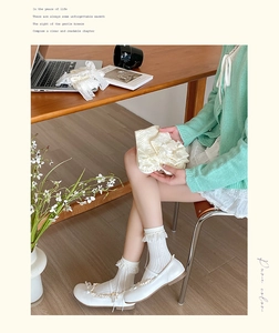 Detailed close-up of white lolita lace trim socks with sweet bow knots in a soft scene