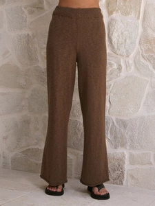 Détail d'un pantalon large en maille marron foncé avec taille haute et ourlet roulé