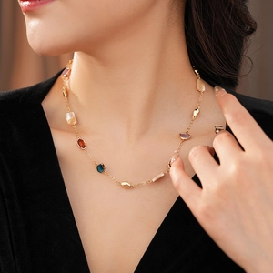 Détail d'un collier vintage doré avec incrustations de nacre et gemmes sur modèle