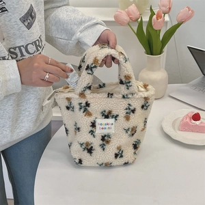 Detail view of beige fleece floral tote bag being used for small item storage