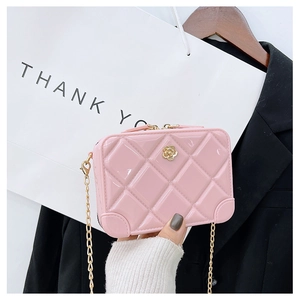Detailed close-up of pink quilted PVC jelly bag with golden camellia and chain strap