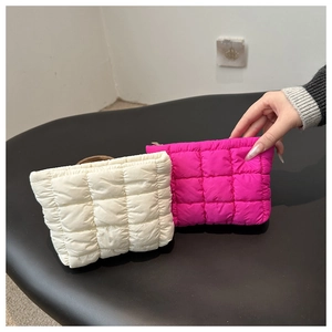 Detailed view of cream and magenta quilted puffer pouches with soft cloud-like texture