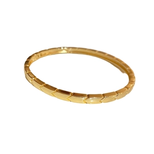 Modern gold-plated chevron patterned bangle with a polished geometric textured finish