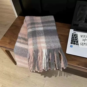 Detail of pink and grey plaid scarf with soft fringe on a wooden bench setting