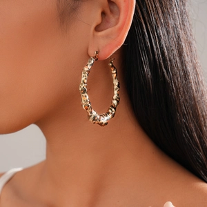 Créoles dorées style bambou avec motif léopard portées par un mannequin femme