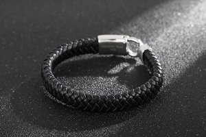 Vue détaillée du fermoir en acier 316L et de la texture du cuir tressé noir