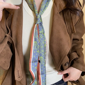 Detail of silk-feel scarf necklace with paisley print in grey-blue and green tones