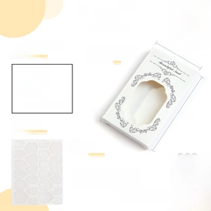 Detailed press-on nail kit featuring white French nails, adhesive tabs, and manicure tools