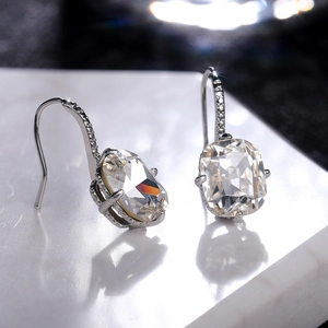 Macro shot of cushion-cut crystal drop earrings with pave-set stones in silver finish