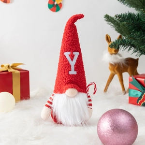 Three Christmas gnomes in red and white with JOY letters on cozy faux fur rug