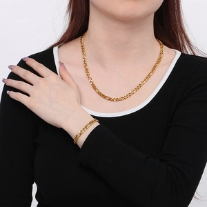 Golden Figaro chain necklace and bracelet set in stainless steel worn by a model