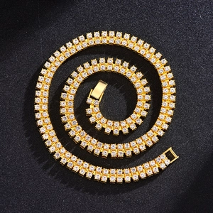 Detailed top view of gold double-row Cuban link necklace with sparkling rhinestones on black