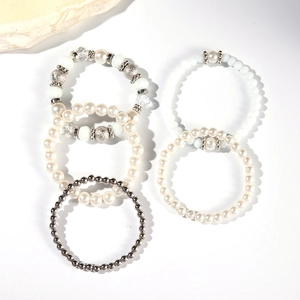 Vista dettagliata del set di 5 braccialetti elastici multistrato con perle bianche e argento
