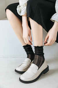 Detail of beige loafers and black mesh lace crew socks with ruffle trim style