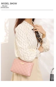 Close-up of quilted pink crossbody bag with gold metal plate and chain strap