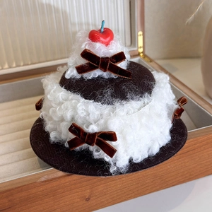 Detail of creative cherry cake hair clip with faux fur and velvet bows in a wooden box