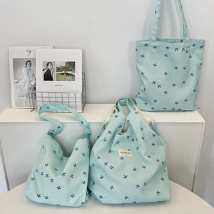 Detailed set of light blue canvas bags featuring dark blue bird print and branding label