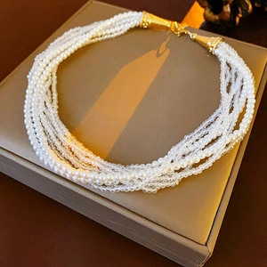 Detail of bohemian multilayer necklace with white pearls and faceted crystal beads