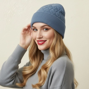 Close-up of dark blue knitted beanie showing thick textured square weave and ribbed edge