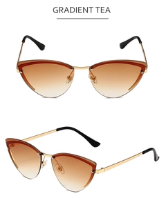 Detail view of gold metal cat-eye sunglasses with gradient tea lenses and rimless frame