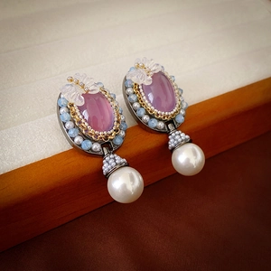 Detail of vintage oval purple crystal earrings with white beads and large pearl drops
