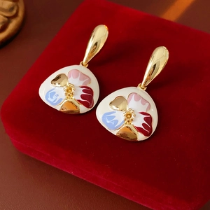 Detail of vintage flower earrings with colorful enamel on a red velvet jewelry box