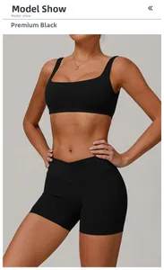 Model trägt premium schwarzen Sport-BH mit Karree-Ausschnitt und Fitness-Shorts