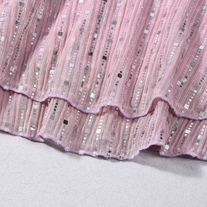 Détail du tissu plissé rose avec paillettes carrées argentées et coutures délicates