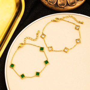 Detailed view of 18K gold plated bracelets with emerald green and white square zircons