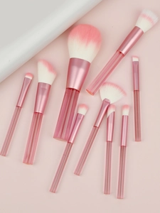 Detail of 9-piece makeup brush set with pink gradient bristles and clear textured handles