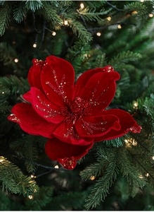 Detail of red velvet Christmas magnolia flower with gold glitter on a decorated tree