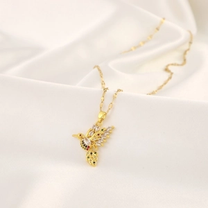 Detailed view of hummingbird pendant with colorful crystals on elegant silk background