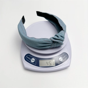 Serre-tête en denim bleu avec nœud sur une balance indiquant un poids de 45,1g