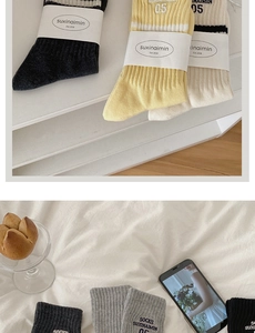 Close-up of ribbed cotton crew socks in navy, yellow, cream, and grey with letter embroidery
