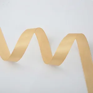 Macro detail of glossy champagne gold satin ribbon texture and smooth fabric edges