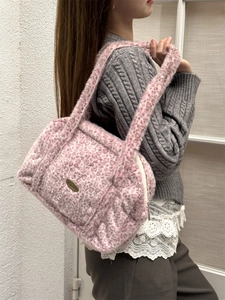 Detail der rosa Leoparden-Plüschtextur und des Metalllogos der Kunstpelz-Schultertasche