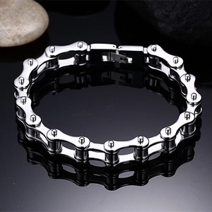 Macro shot of silver stainless steel bike chain bracelet on a black reflective surface