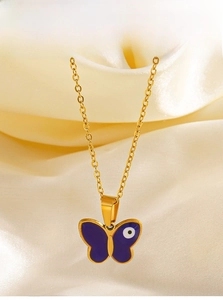 Close-up of golden butterfly necklace with purple enamel and devil eye detail on silk