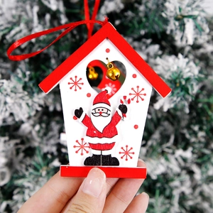 Detail of wooden Christmas house ornament with Santa pattern and golden bell