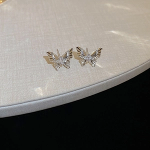 Macro view of silver butterfly stud earrings featuring shimmering cubic zirconia stones