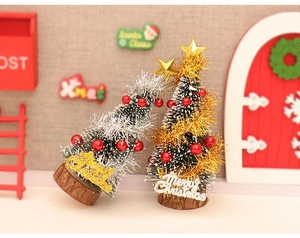Macro detail of miniature Christmas trees with gold and silver tinsel on wooden bases