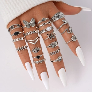 Detailed view of silver gothic ring set featuring butterfly, snake, and pearl motifs
