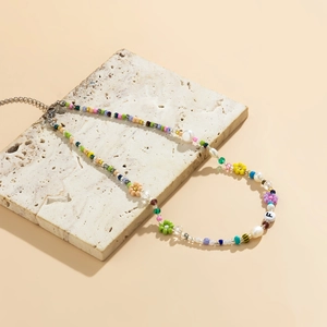 Daisy beaded necklace with freshwater pearls and letter F charm on beige stone