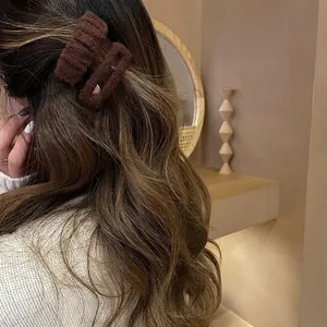 Two-piece dark brown plush hair clips for women shown on a model for autumn winter style
