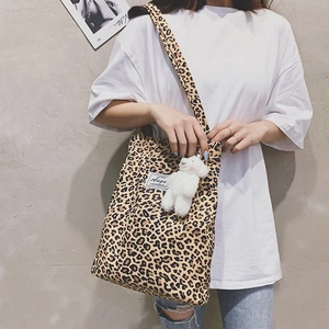 Detailed leopard print canvas tote bag featuring a white plush charm and brand tag