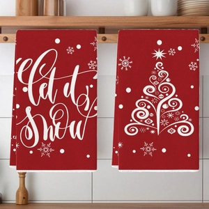 Detail of red Christmas kitchen towels with Let it Snow text and white Xmas tree pattern