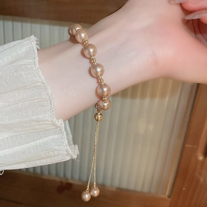 Detail of adjustable French vintage pearl bracelet with gold metal beads on wrist