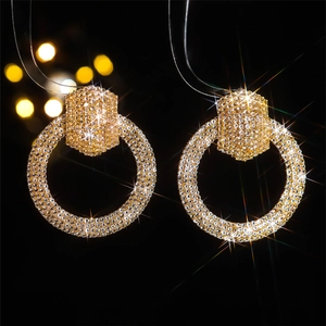 Close-up of gold hoop earrings with pavé crystals and sparkling light effect