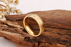 Détail d'une bague en titane doré avec trois zircons sur un support en bois élégant